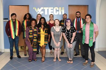 group of students wearing their graduation stoles indicating home country, kente cloth, LGBTQ cords
